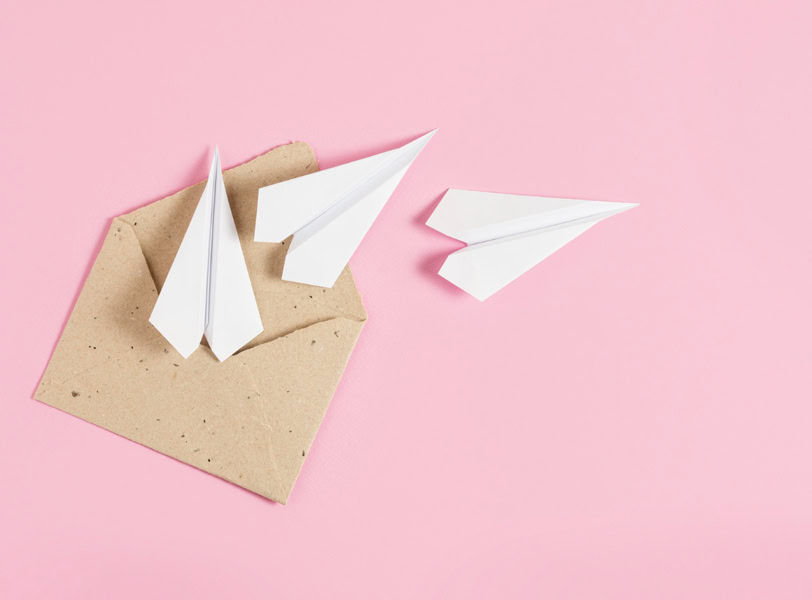 Image d'une enveloppe sur fond rose, symbolisant l'inscription à la newsletter sur le bien-être des bébés.