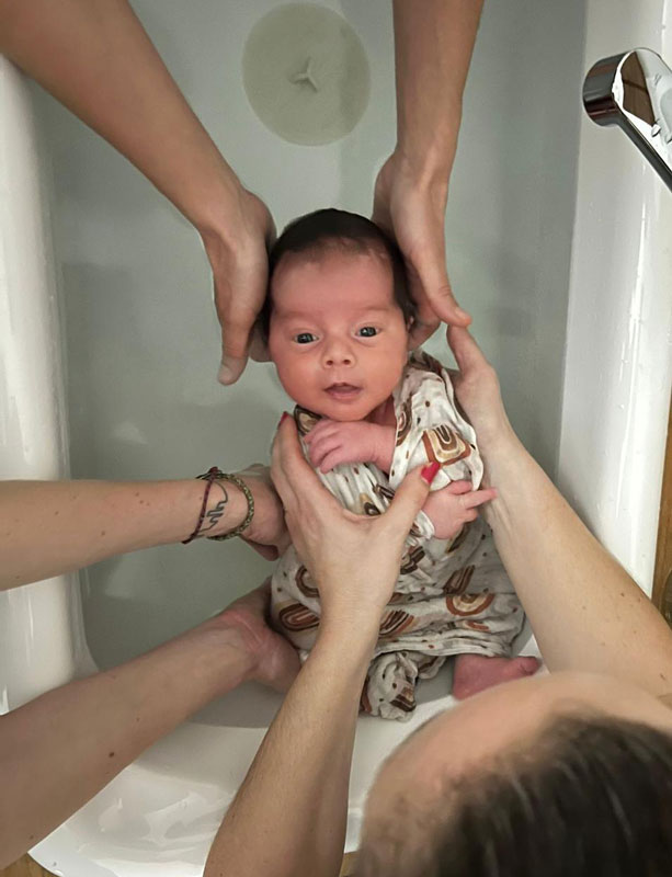 Bébé dans un bain coco chiro, entouré de mains sécurisantes pour libérer les tensions et favoriser le bien-être.