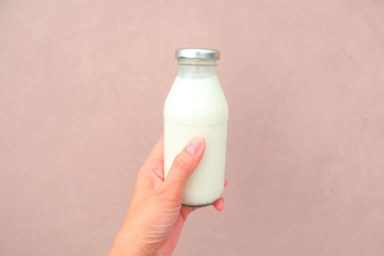 Bouteille de lait sur fond rose, pour illustrer une recette de gel douche au lait maternel