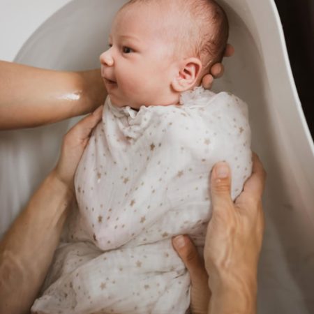 Bébé emmailloté dans un lange pour un bain paisible